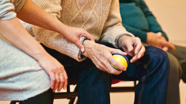 a caregiver holding an elderly persons hand